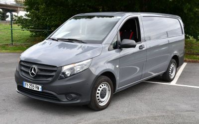 Une fourgonnette Mercedes Classe V garée sur un parking, avec des arbres en arrière-plan