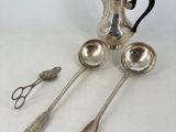 three spoons and a teapot on a table with silverware