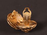 a close up of a gold plated metal object on a black surface