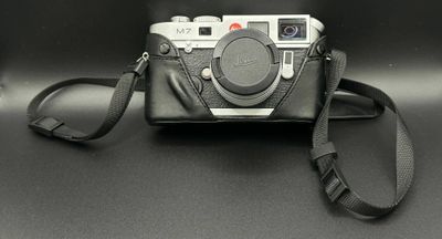 a black camera with a black strap on a black table
