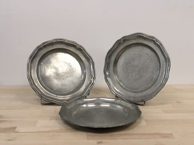 trois assiettes en argent posées sur une table en bois