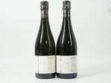 deux bouteilles de vin posées l'une à côté de l'autre sur une surface blanche