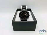 a close up of a watch in a box on a white surface
