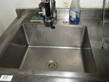 a stainless steel sink with a bottle of water in it