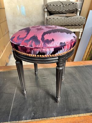 un tabouret rembourré orné d'un motif violet et noir