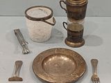 a silver plate and silverware on a white table