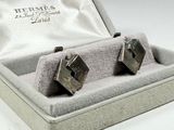 a pair of cufflinks sitting in a box on a table