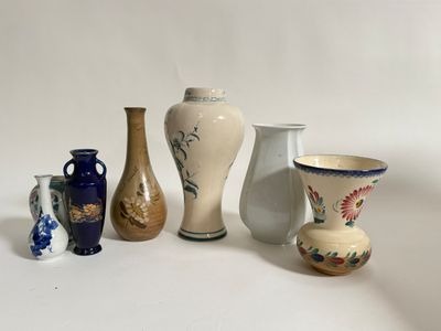 five different vases sitting on a white surface