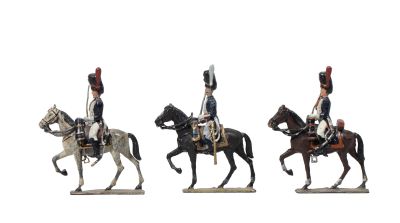 trois figurines représentant des hommes à cheval sur fond blanc