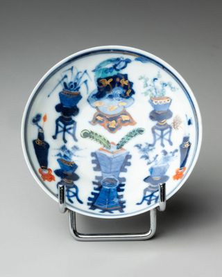 blue and white plate with a design of animals and plants