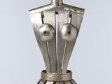 une sculpture en argent représentant un mannequin posé sur une table blanche