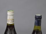 two bottles of wine sitting next to each other on a table