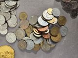 a pile of coins sitting on a table next to a gold coin