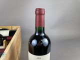 a bottle of red wine sitting next to a wooden box