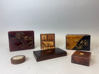 quatre petites boîtes en bois et une horloge posées sur une surface blanche