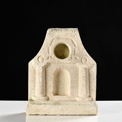 sculpture représentant un bâtiment en pierre percé d'un trou au milieu