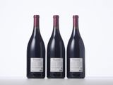 three bottles of red wine are lined up on a table