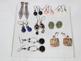 Plusieurs paires de boucles d'oreilles sont exposées dans une vitrine transparente.