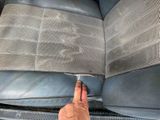 a hand that is pointing at the seat of a car