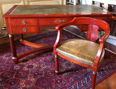 un bureau, une chaise et un tapis dans la pièce