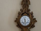 une horloge accrochée au mur à côté d'une lampe