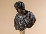 a statue of a woman on a pedestal next to a vase