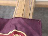 a red and gold flag on a wooden bench