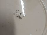 a person holding a white plate with a black writing on it