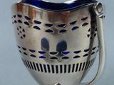 a silver cup with a blue handle on a silver stand