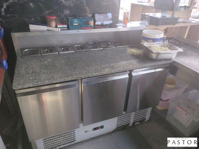 une photo d'une cuisine équipée d'appareils électroménagers en inox et de plans de travail en granit