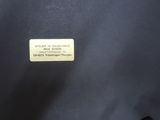 the back of a black jacket with a gold label on it