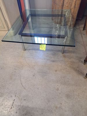 une table en verre sur laquelle est posé un panneau, au milieu d'une pièce