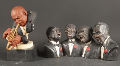 a statue of a man playing a trumpet next to a group of busturines