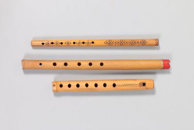 three flutes are lined up on a white surface