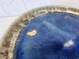 a blue bowl with a heart on it sitting on a table