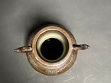 a brown vase with a black hole in it
