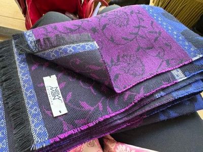 Des écharpes violettes et bleues sont empilées les unes sur les autres sur une table