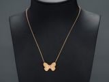 un collier en or avec un pendentif en forme de papillon sur un mannequin