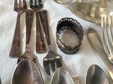 many silver spoons, forks and spoons laid out on a table