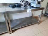 une table en acier inoxydable sur laquelle sont posés des plats, dans une cuisine