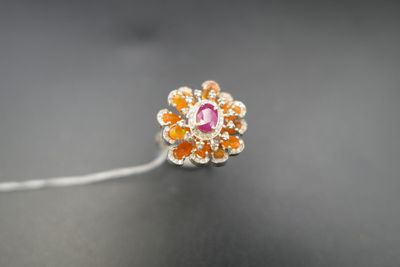 un gros plan sur un anneau de fleurs orange et blanches posé sur une surface noire