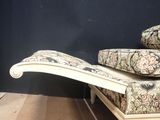 a chaise with pillows on top of it in a room