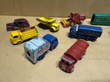 Plusieurs camions miniatures sont alignés en rang sur une table