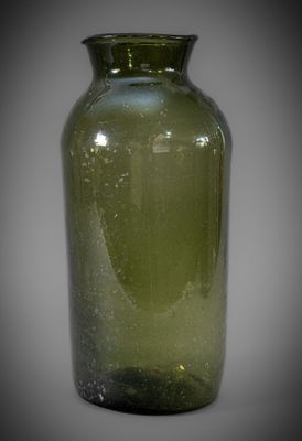 a green glass vase that is sitting on a table