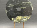 sculpture of a black and white marble disc on a wooden stand