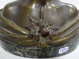 bronze bust of a woman with a flower in her hair