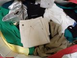 a suitcase full of clothes and clothes on a bed