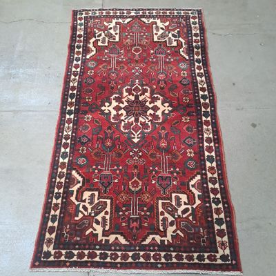Le tapis posé au sol est rouge et blanc, avec un motif