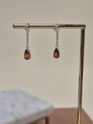 une paire de boucles d'oreilles posée sur un support posé sur une table