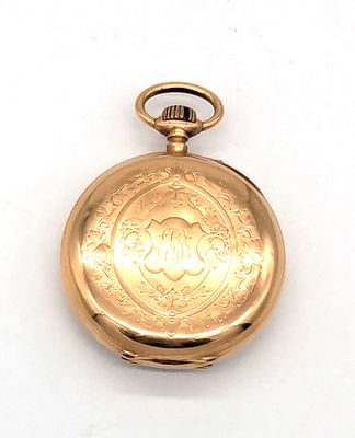 une montre de poche en or sur une surface blanche